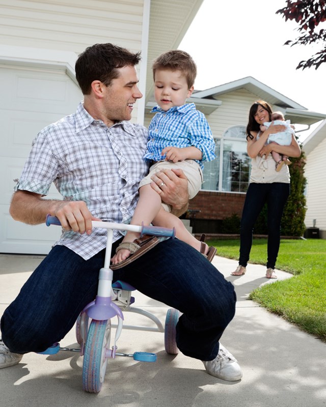 young happy family playing outside of house